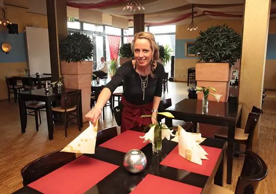 Restaurant Charisma Kellnerin deckt Tisch