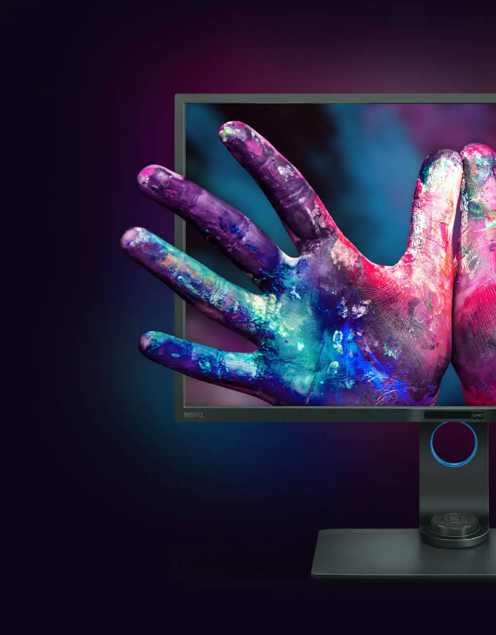 Hände voller Farben die aus einem Bildschirm von BenQ herausragen.