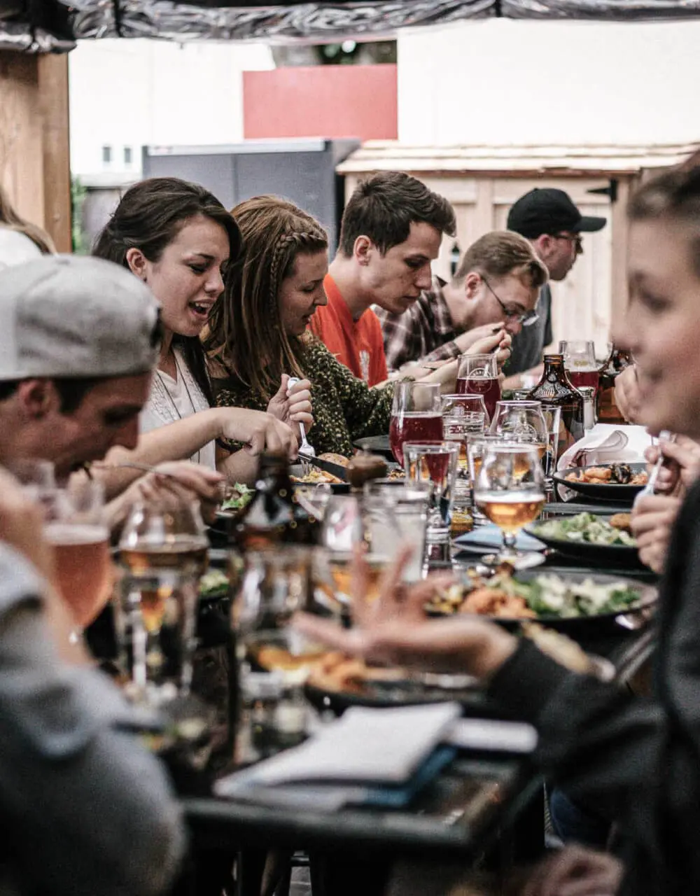 Gruppe von Leuten die gemeinsam am Tisch sitzen und essen.