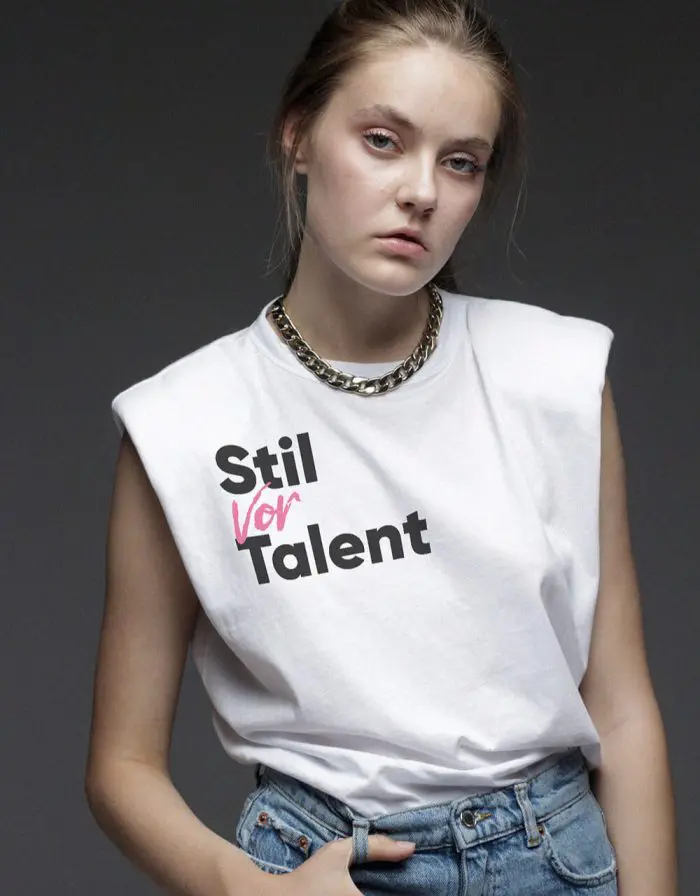 Junge Frau mit großer Halskette trägt ein Shirt von OMB Oh, my Brand!