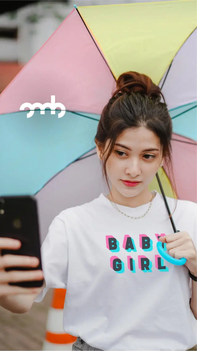 Junge Frau mit buntem Regenschirm trägt das BABY GIRL Shirt von Oh, my Brand!